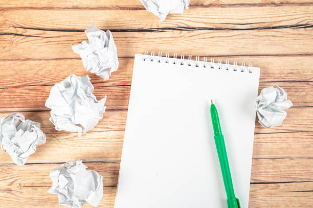 istock Paper balls and pen over blank white sheet - Creativity crisis concept 1301446891