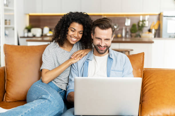 istock Multiracial couple with a laptop on the couch 1301449466