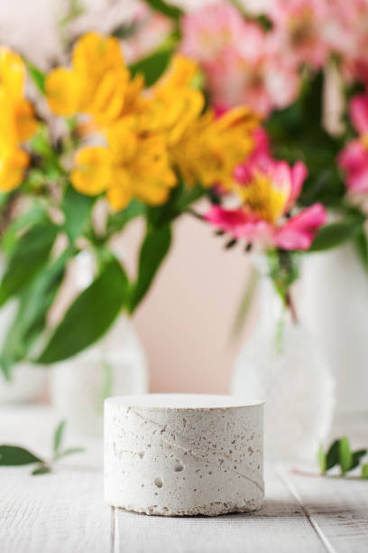 istock Empty concrete podium for your product presentation with flowers on the background in a spring mood. 1301449762