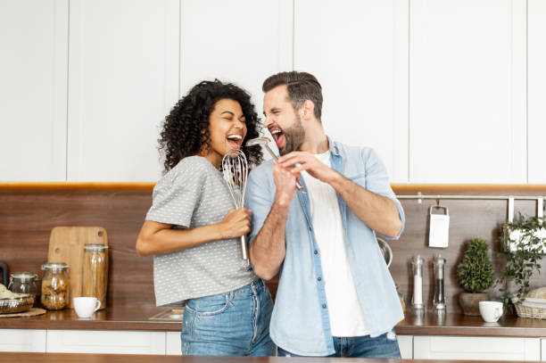 Happy interracial couple dancing in the kitchen