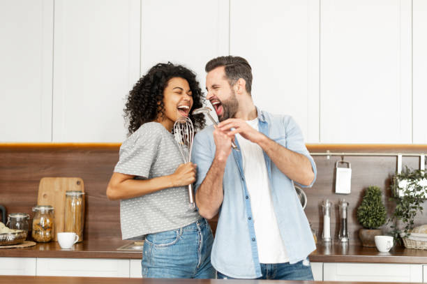 happy interracial couple dancing in the kitchen - couple young adult african descent multi ethnic group imagens e fotografias de stock