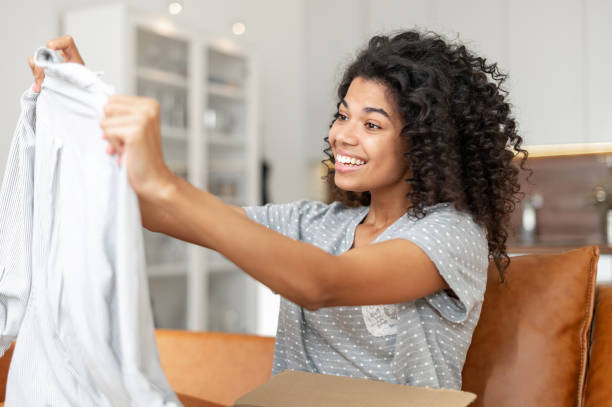 istock woman with an Afro hairstyle unpacking parcel box 1301450186