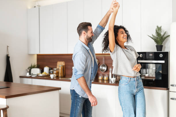 istock Romantic interracial couple dancing in the kitchen 1301450236