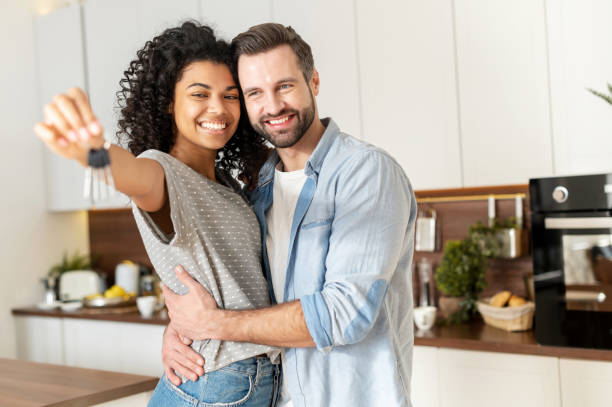 istock Interracial couple holding a key ring in hand 1301450377