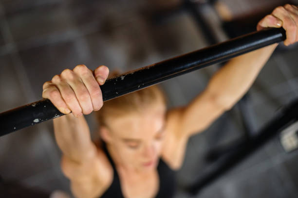 istock Fit young woman doing chin-ups during a gym workout session 1301450440