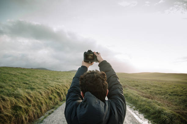 A young man taking a picture with a DSLR camera