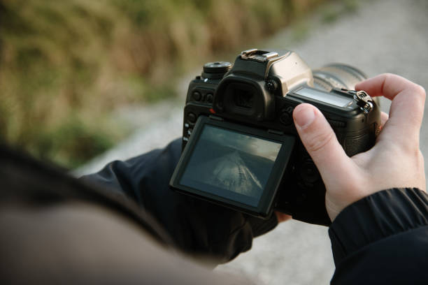 istock Young man taking a picture with a DSLR camera 1301454694