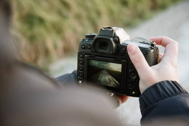 istock Young man taking a picture with a DSLR camera 1301454699