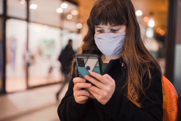 istock School girl wearing protective mask when text messaging 1301455819