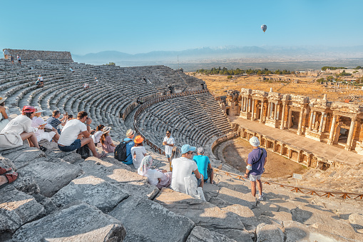 08 September 2020, Pamukkale, Turkey: The guide tells a group of tourists about ancient Greek drama and tragedy and mythology in an ancient amphitheater in the city of Hierapolis in modern Turkey.