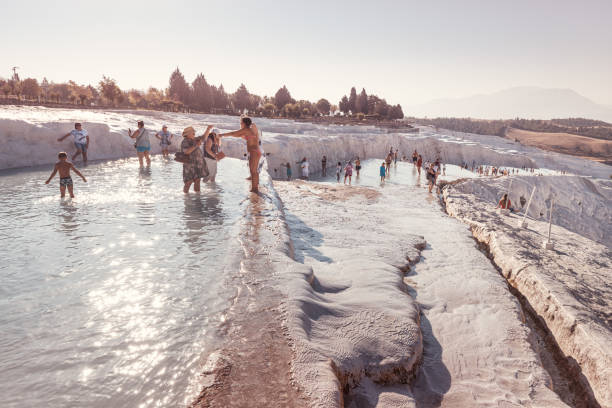 groups of tourists visit the famous pamukkale resort with white calcite baths and hot springs. excursions and tours during the corona virus epidemic - adulation organized group standing out from the crowd individuality imagens e fotografias de stock