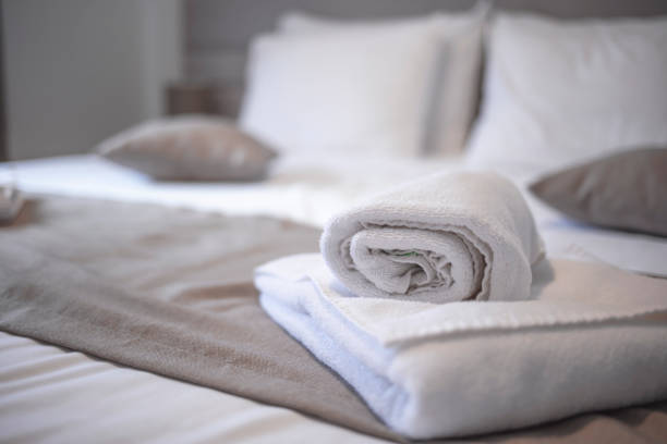istock Clean towels on bed at hotel room. 1301456703