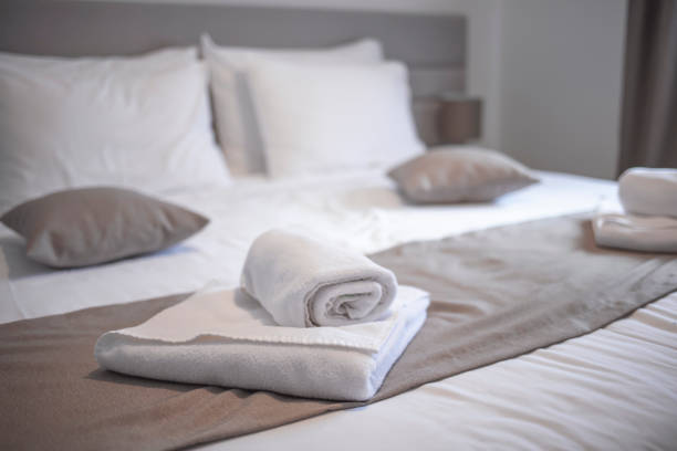 istock Clean towels on bed at hotel room. 1301457858