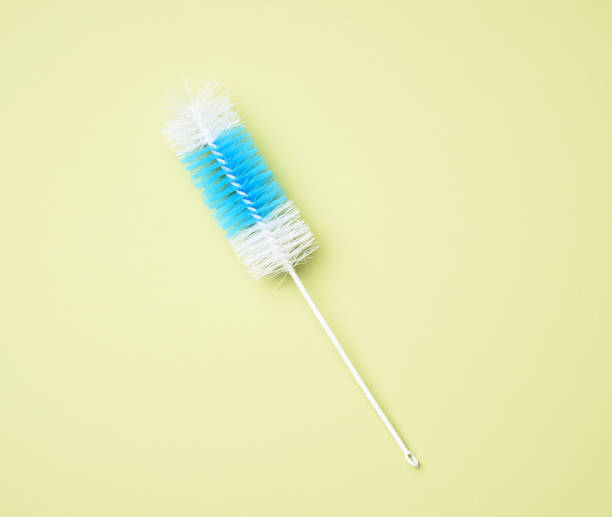 brush for washing bottles on a green background, top view
