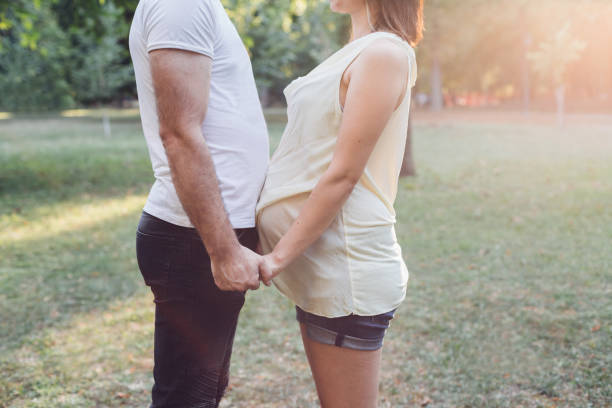 istock Pregnant Couple Holding Hands 1301462315