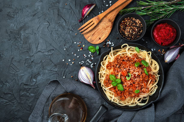 istock Hot dish with spaghetti and thick sauce on a black background 1301465762