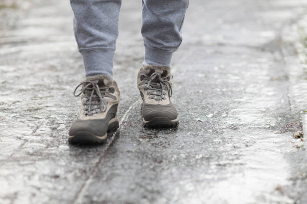 istock A pedestrian walks along a dangerous icy sidewalk. Frozen rain 1301465887