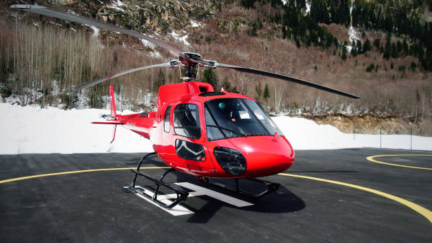 roter kommerzieller hubschrauber am hubschrauber - airfield mountain snow airport stock-fotos und bilder