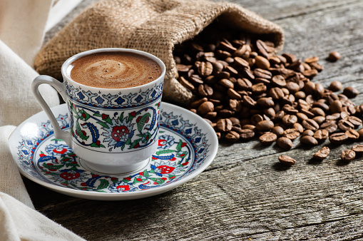 Turkish coffee concept, cup of coffee with coffee beans on wooden background