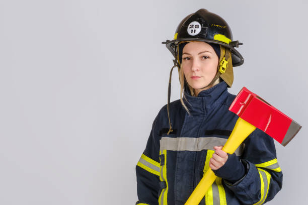 istock Young woman in uniform of firefighter with axe 1301469846