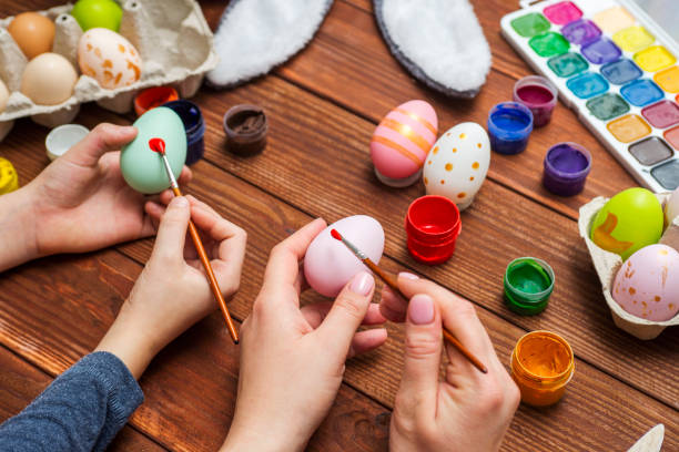 istock Mother and son are painting Easter eggs. Preparing decorations for Easter, creativity with children, traditional symbols. Preparing for Easter. 1301470549