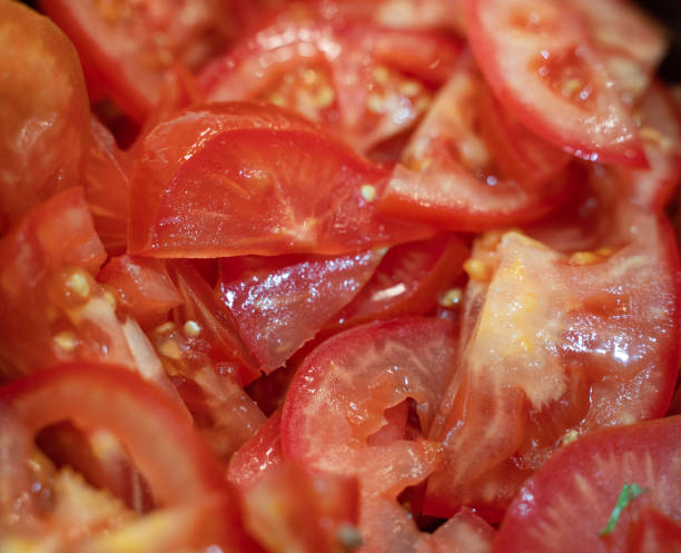 istock Fresh sliced tomato pieces background. selective foucs 1301470751