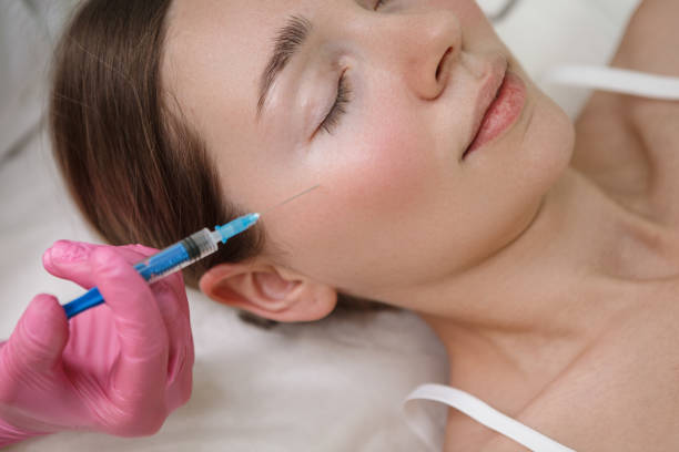 mujer recibiendo tratamiento de belleza en clínica de cosmetología - mejilla fotografías e imágenes de stock