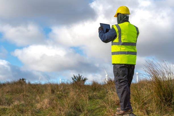 istock The rear view of a man using a digital tablet while out working in a remote location near wind turbines 1301474743
