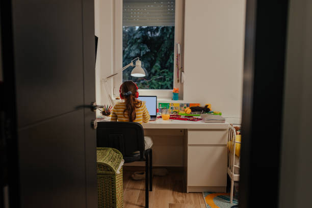 istock Little girl doing her homework at home 1301478545
