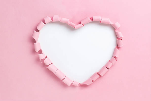 istock Large heart-shaped hole in pink paper 1301482977