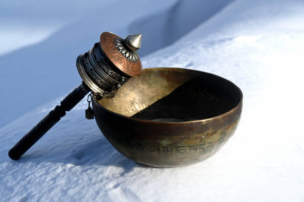 Handmade prayer wheel and singing bowl for buddhism on snow A handmade prayer wheel and tibetan singing bowl for buddhism on snow buddhist prayer wheel stock pictures, royalty-free photos & images