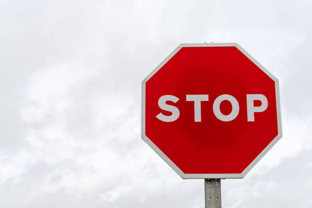 istock horizontal view of a bright red stop sign with a gray overcast sky behind 1301485998