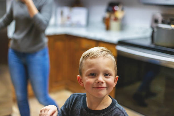 millennial mother and son spending time together at home in the kitchen mother's day photo series - love growth time of day cheerful imagens e fotografias de stock