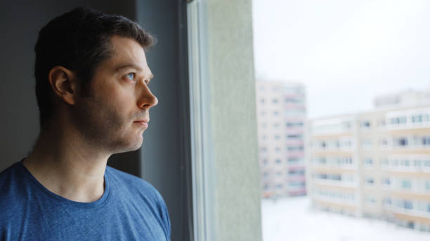 istock Thoughtful handsome man looks out the window. 1301489310