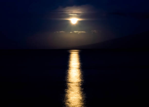 Full Moonset Over Ocean with Reflection on Water stock photo