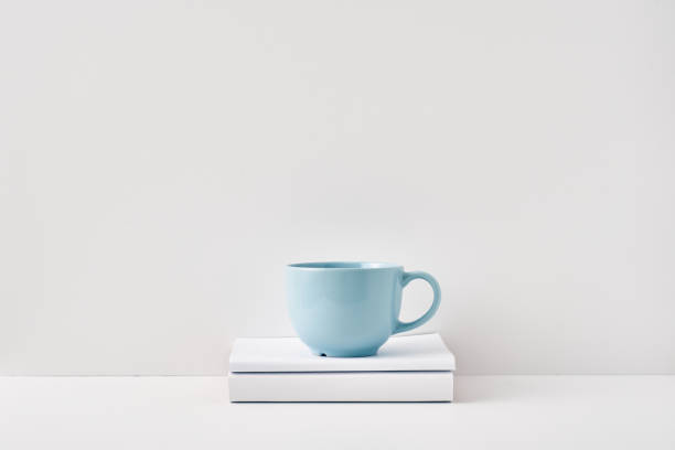 istock The mug stands on a stack of books on a white background. Natural and eco-friendly materials. Copy space, mock up 1301492567