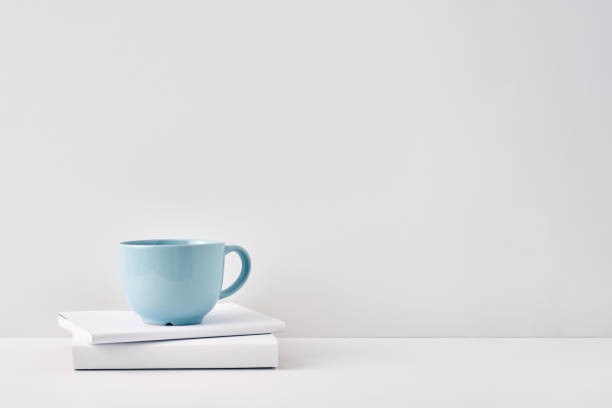 istock The mug stands on a stack of books on a white background. Natural and eco-friendly materials. Copy space, mock up 1301492578
