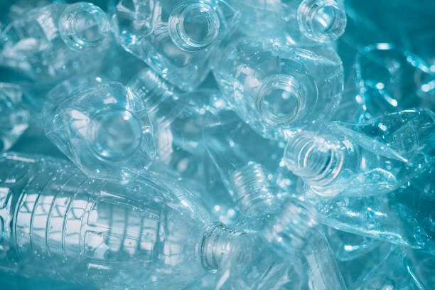 waste management plastic reuse bottles texture Waste management. Plastic reuse. Environmental protection. Save nature. Blue wet clean empty creased bottles pile texture background. plastic stock pictures, royalty-free photos & images