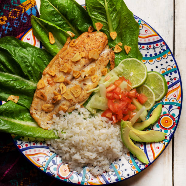 istock Fish steak with garlic, salad and rice on white background 1301496919