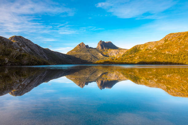 istock Golden mountain range reflected in still lake 1301496960