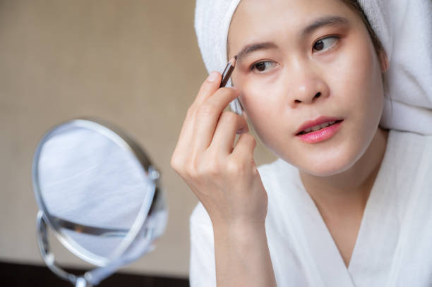 istock Asian woman using eyebrow pencil to apply color to the eyebrows. 1301497868