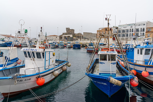 Tarifa, Spain - 27 January, 2021: colorful fishing boats and industrial port and harbor in Tarifa