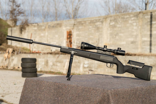 черный полимерный каркас современной пневматической пушки с оптикой на столе на открытом воздухе - rifle sport air target shooting стоковые фото и изображения