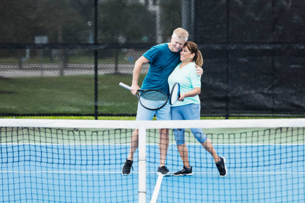 paar spielt tennis, umarmung - tennis court love victory stock-fotos und bilder