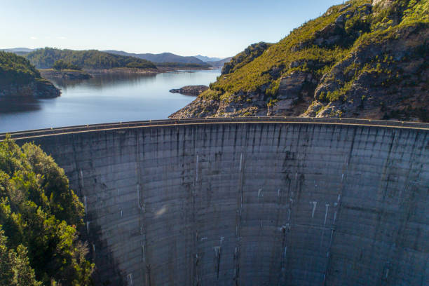 Cement dam wall creating hydro electricity aerial view Cement dam wall creating hydro electricity aerial view in Tasmania dam stock pictures, royalty-free photos & images