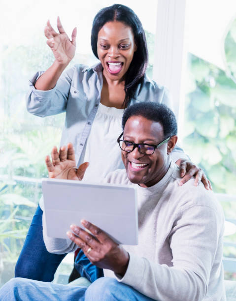 istock Mature couple waving to digital tablet, on video call 1301500431