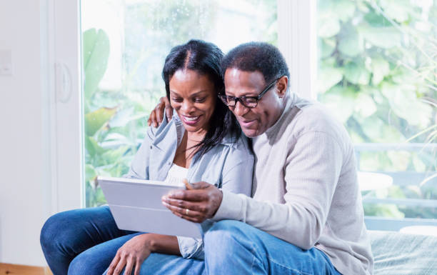 istock Black couple at home using digital tablet for video call 1301500960