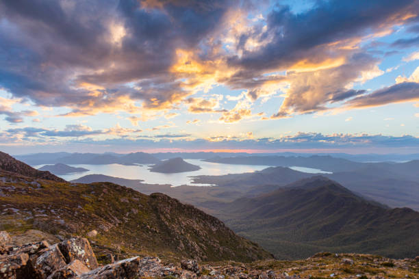 istock Dramatic golden sky over steep dramatic mountain ranges and lake 1301501135