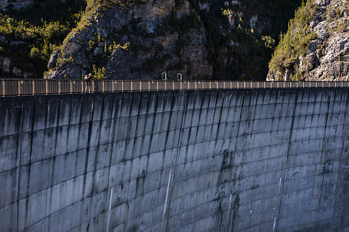 Young male photographer on adventure walking along a hydro electricity dam wall in Tasmania, Australia
