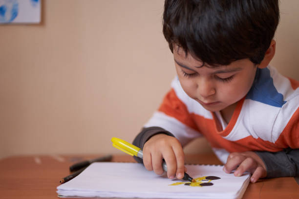 istock child looks at his drawing while coloring it 1301503246